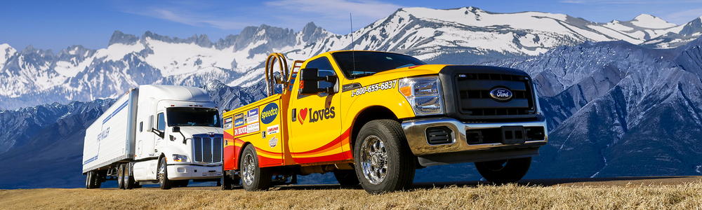 Love's Travel Stops roadside service truck and semi truck with mountains in the background